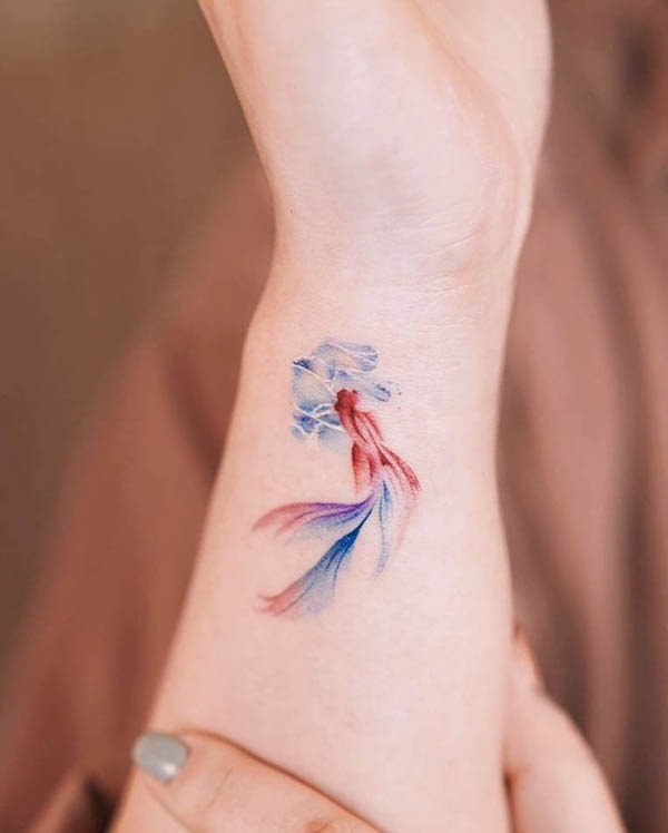Small watercolor koi fish wrist tattoo by @leean.ink