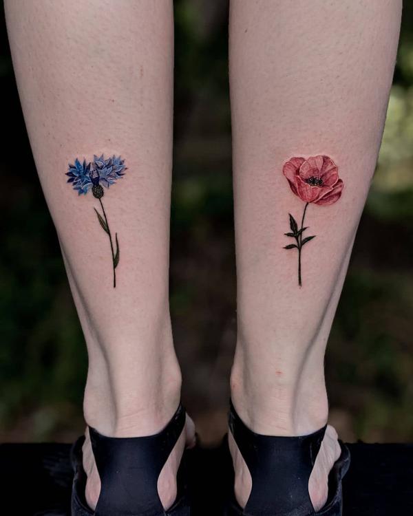 Cornflower and poppy tattoos above ankles