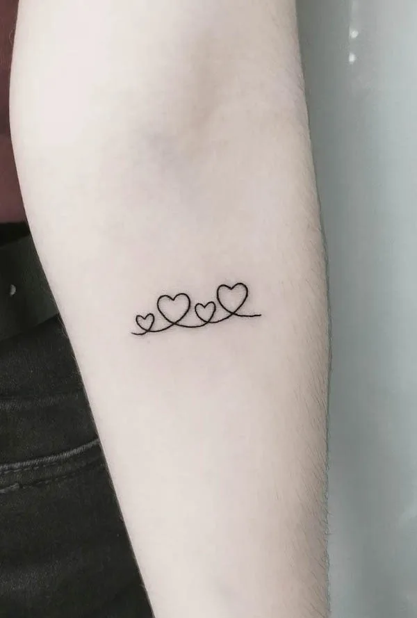 Simple connected hearts family forearm tattoo by @zowie_tattoo