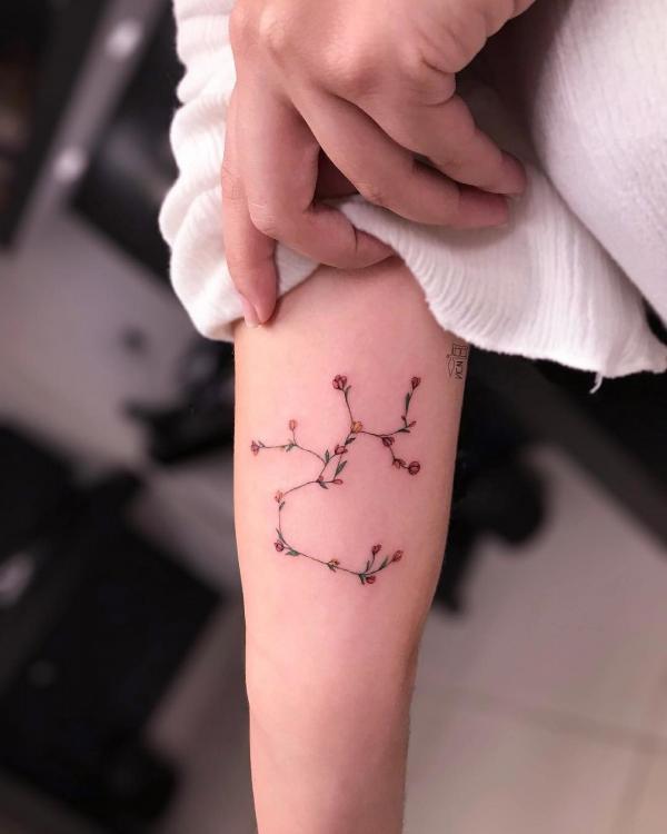 Sagittarius floral constellation forearm tattoo