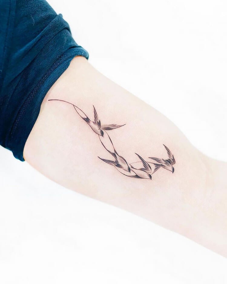 four swallows on arm tattoo