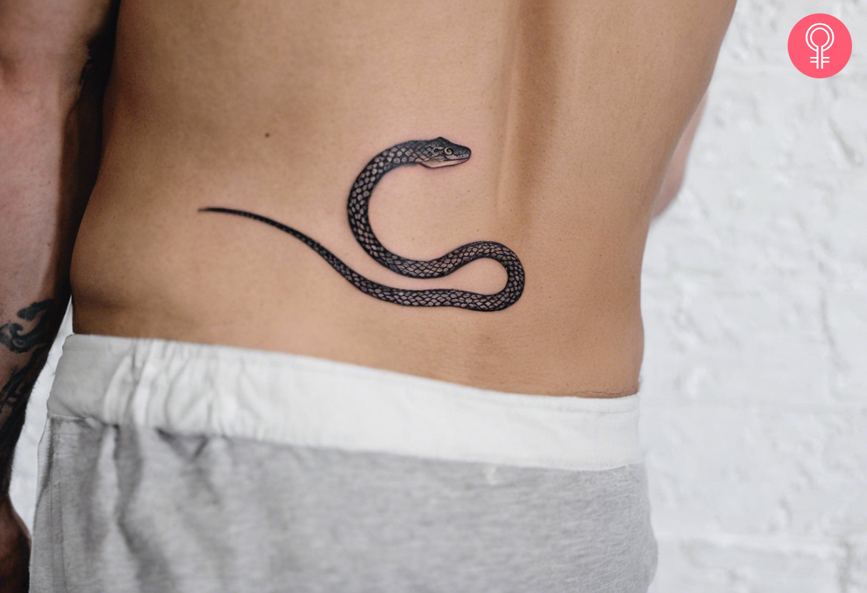 A man wearing a snake tattoo on his lower back