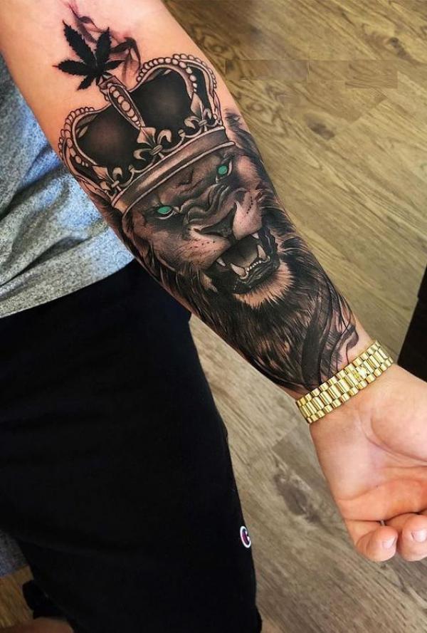 Lion king with crown tattoo on inner forearm