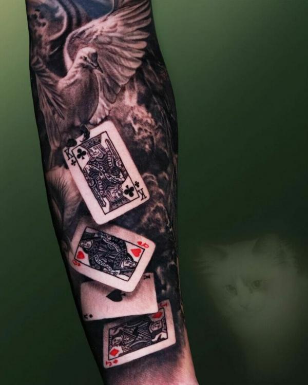 Playing cards with bird tattoo sleeve