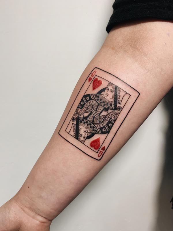 Queen of hearts playing card tattoo on forearm