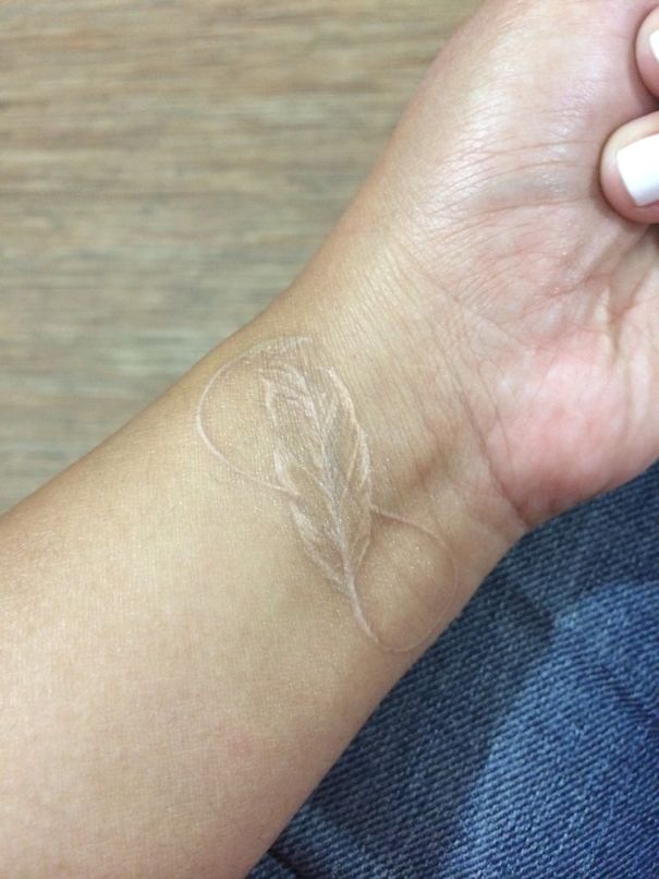 Eternity and feather white tattoo on wrist