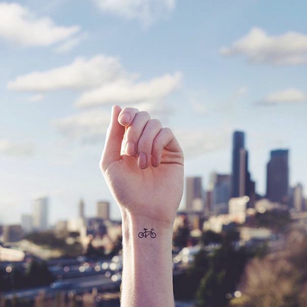 Minimal, black bicycle wrist tattoo