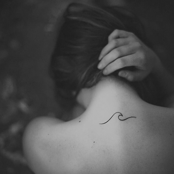 Black linear wave tattoo on back neck