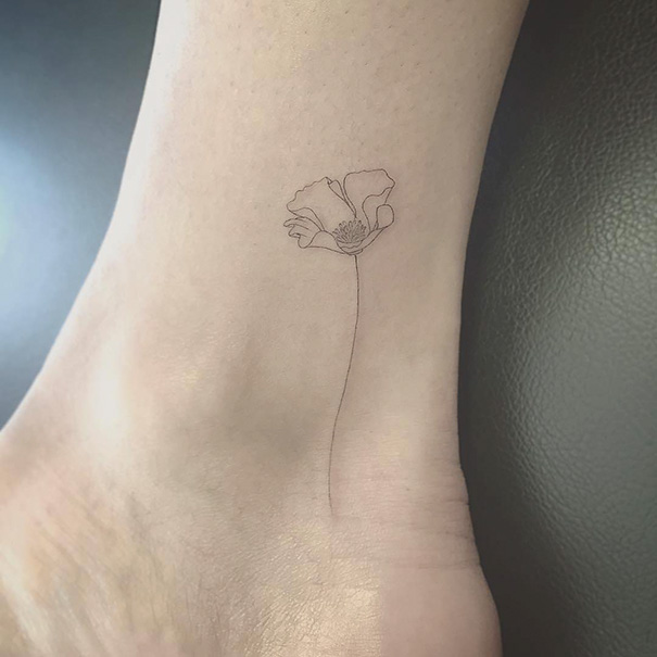 Minimal, delicate, linear flower tattoo on wrist 