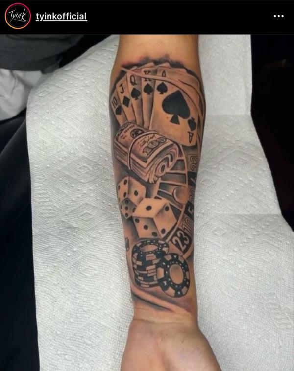 spade playing cards with dice and money tattoo forearm