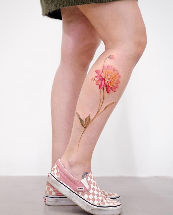 A single dahlia with vine tattoo on lower leg