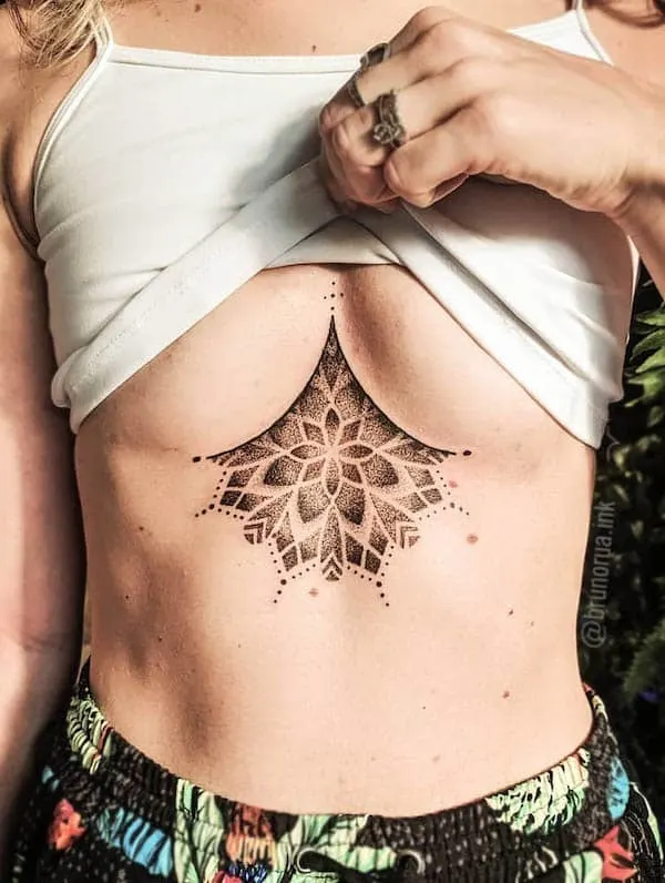 Floral mandala tattoo between boob by @brunorua.ink_