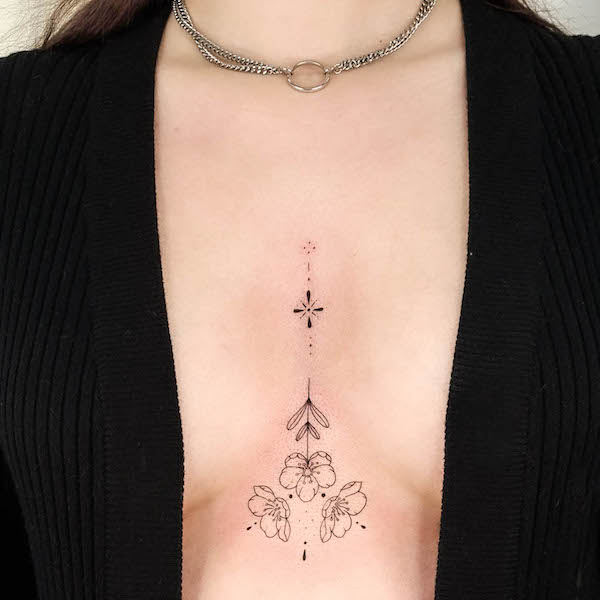 Floral ornament tattoo between boobs by @inuk.tattoo