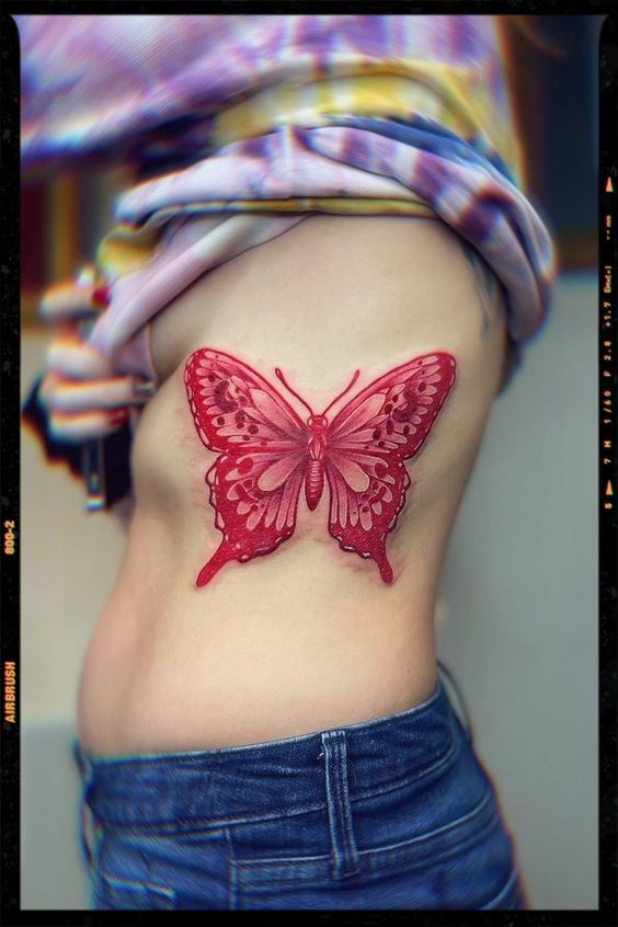 Large red butterfly tattoo on side