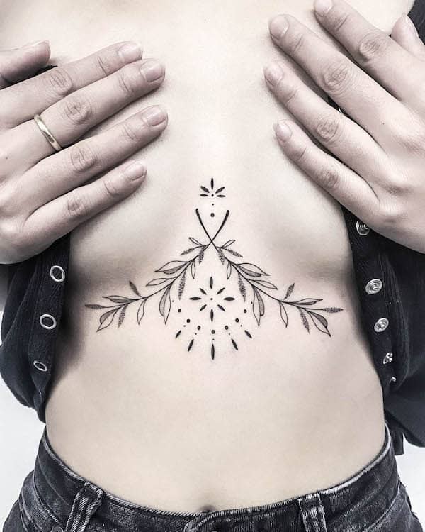 Ornamental tattoo between boobs by @ali.bloom_.tattoo