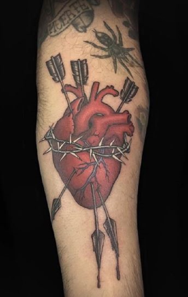 Real heart tattoo with arrow and barbed wire