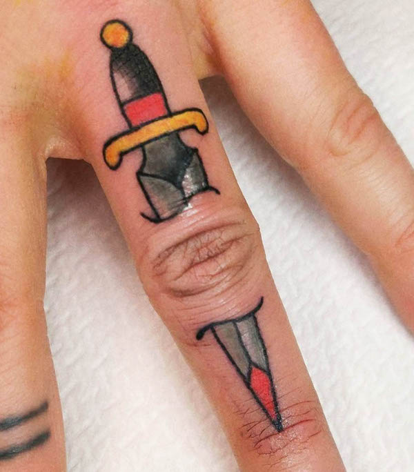 Through the skin dagger finger tattoo by @miekedevliegertattoo