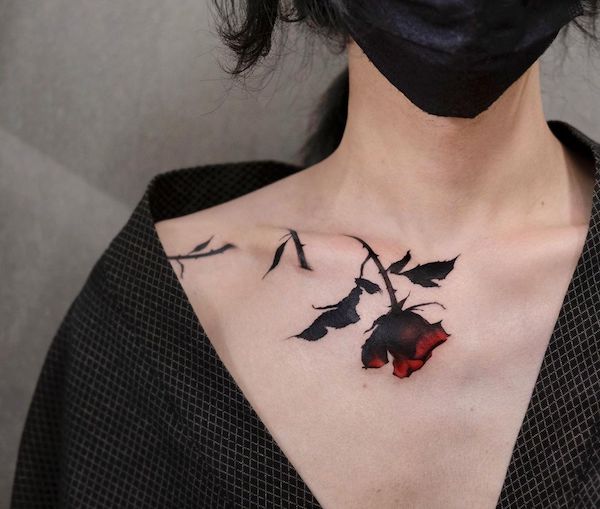 Beauty rose with thorn tattoo on the collarbone