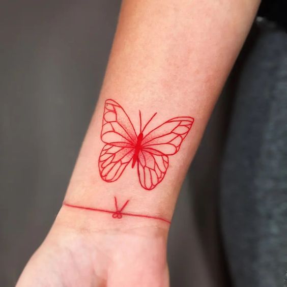 Fine line red butterfly wrist tattoo