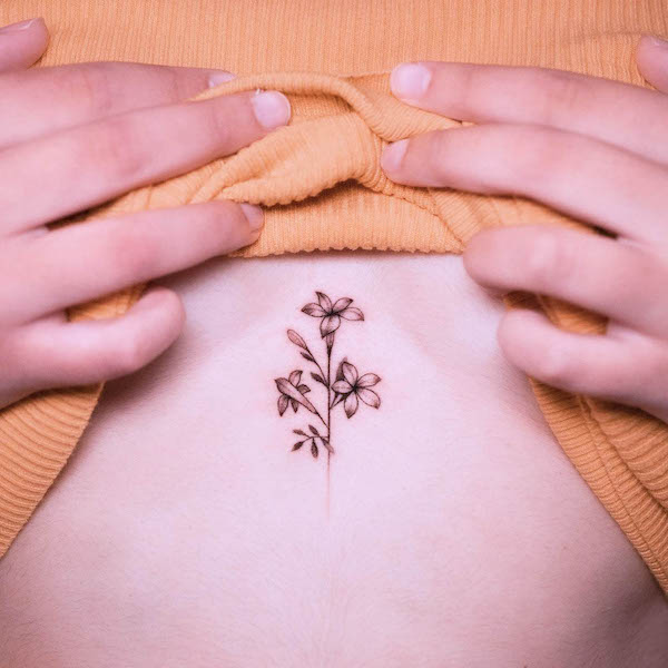 Small middle chest flower tattoo by @pratstattoo