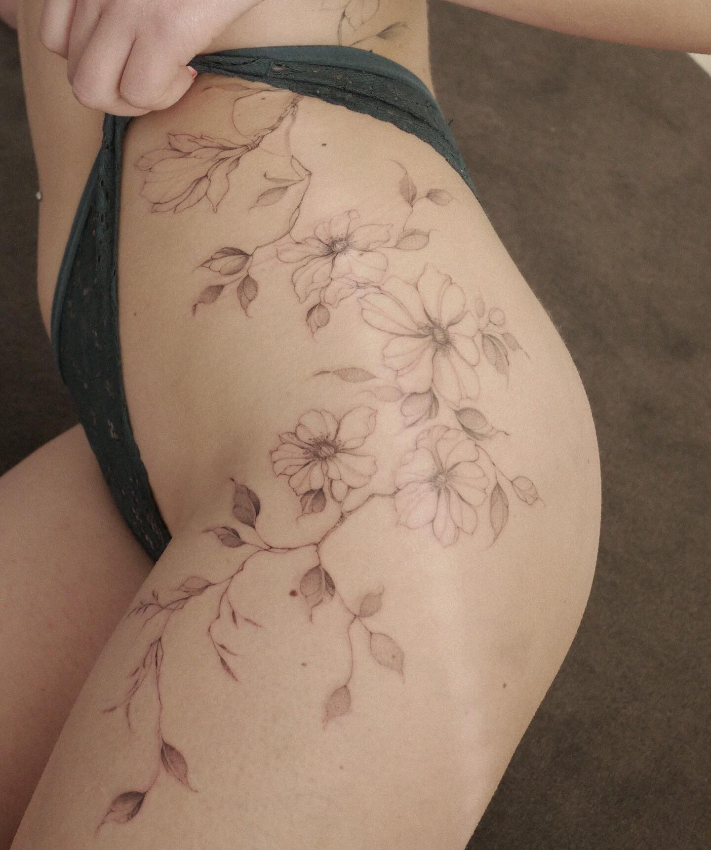 Floral composition tattooed on the hip