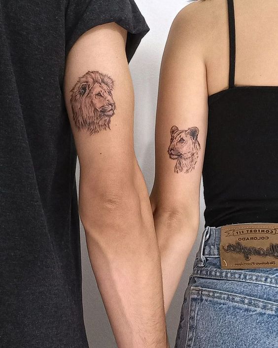 Lion and lioness couple tattoo on the outer arm