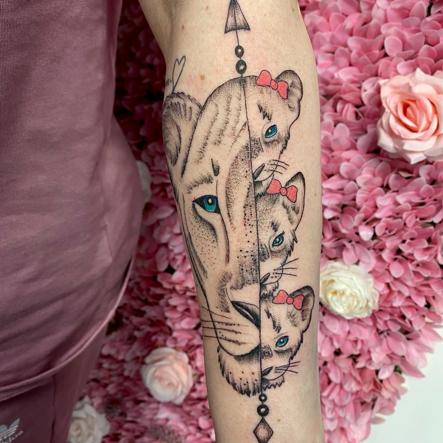 Lioness and her cubs tattooed on the forearm