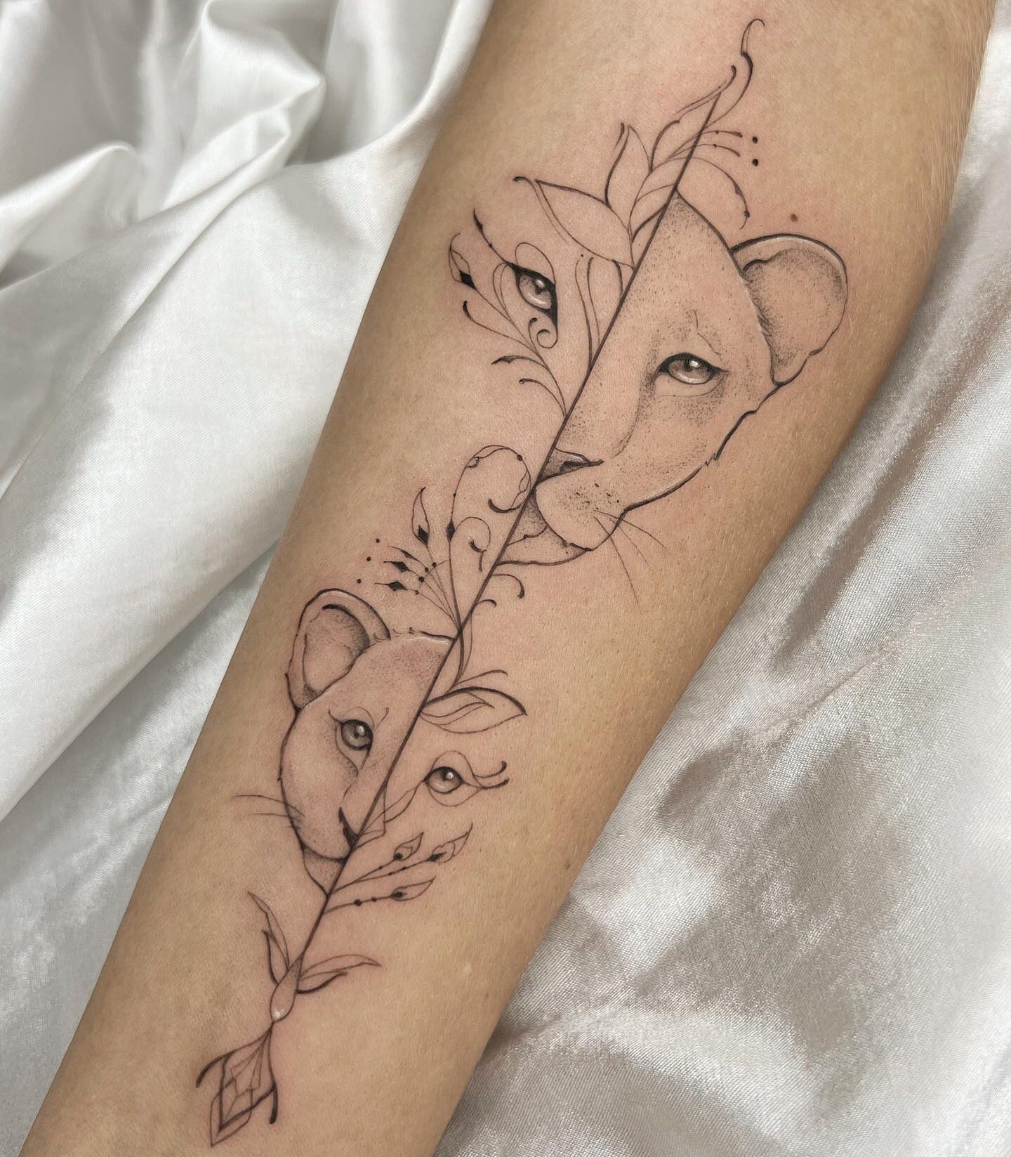 Line work style lioness and cub tattoo on the inner forearm