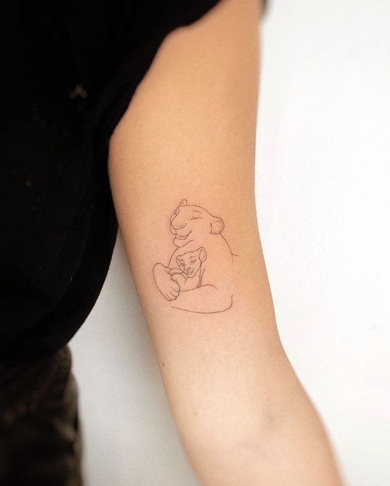 Minimalistic style lioness and lion cub tattoo on the inner arm