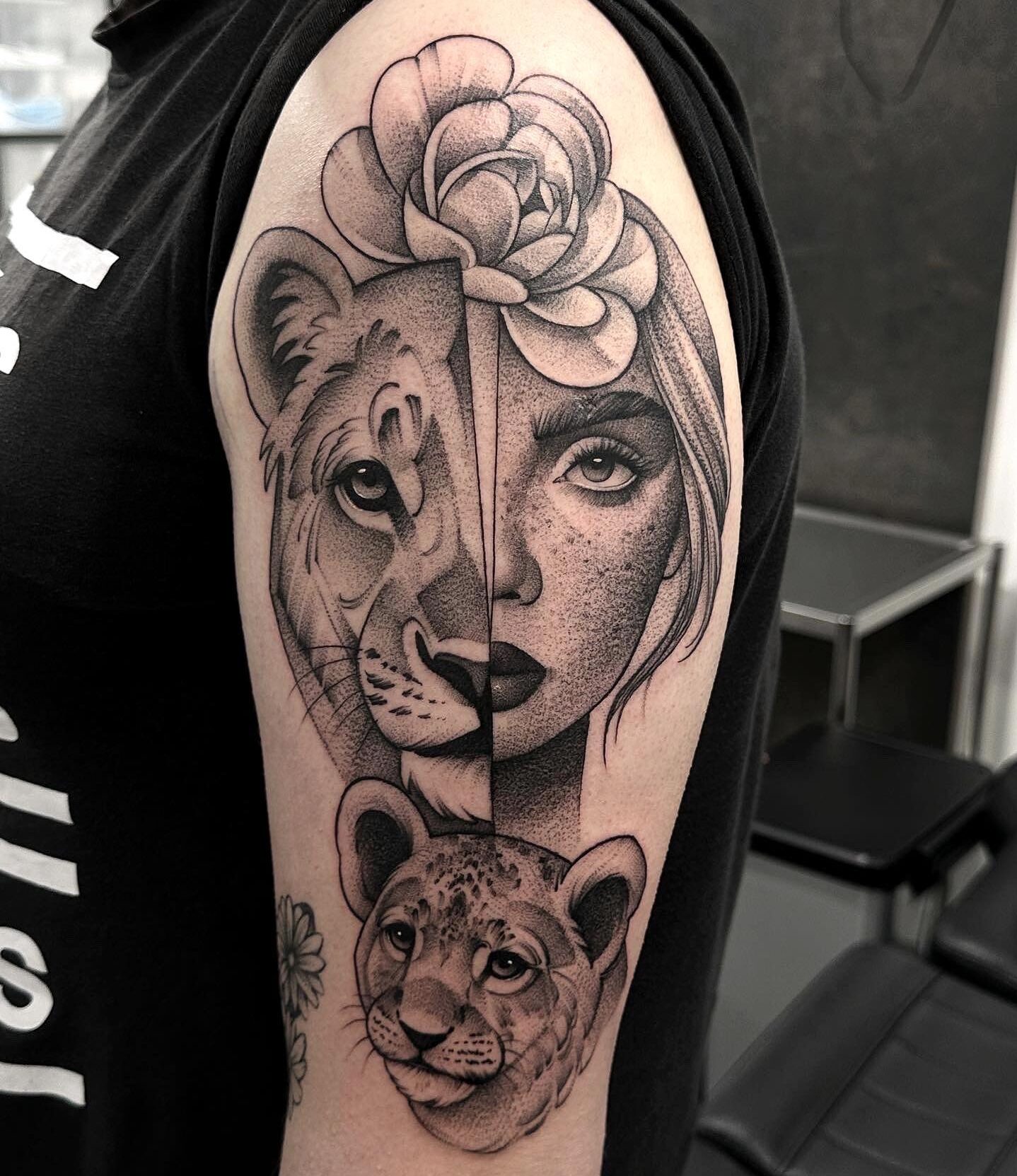 Lioness and lion cub tattoo on the arm