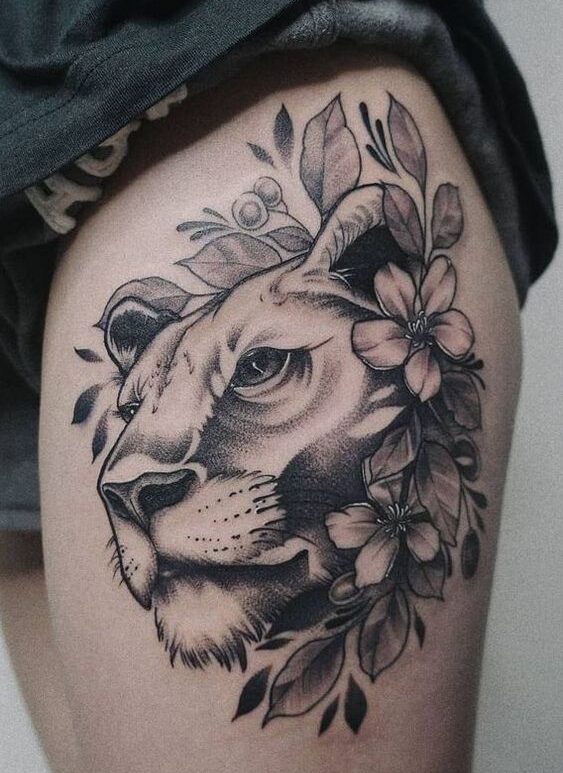 Huge lioness and flowers tattoo on the thigh