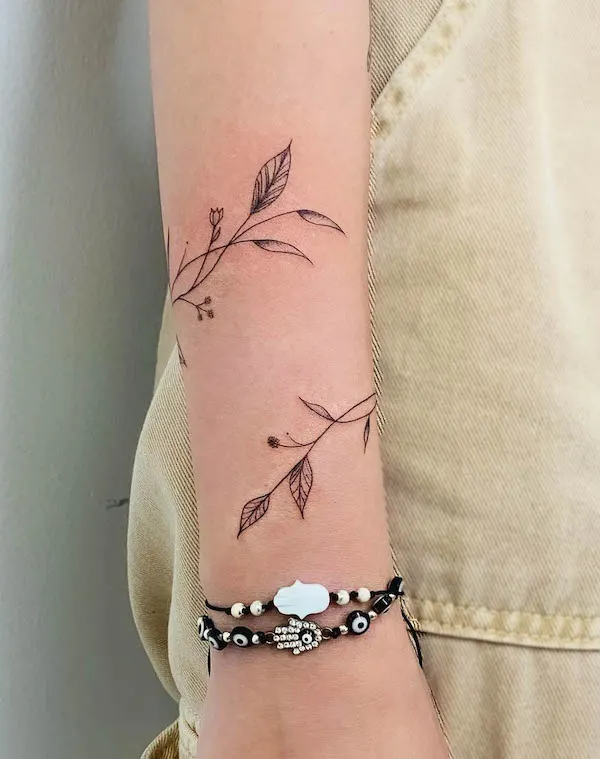 Leaves wrapping around the arm by @lolla_tattoo