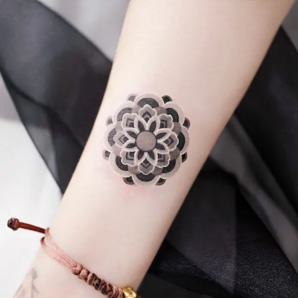 Small black mandala forearm tattoo for women by @leean.ink_