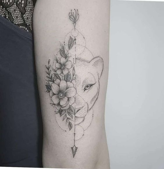 Half lioness and half flowers tattoo on the arm