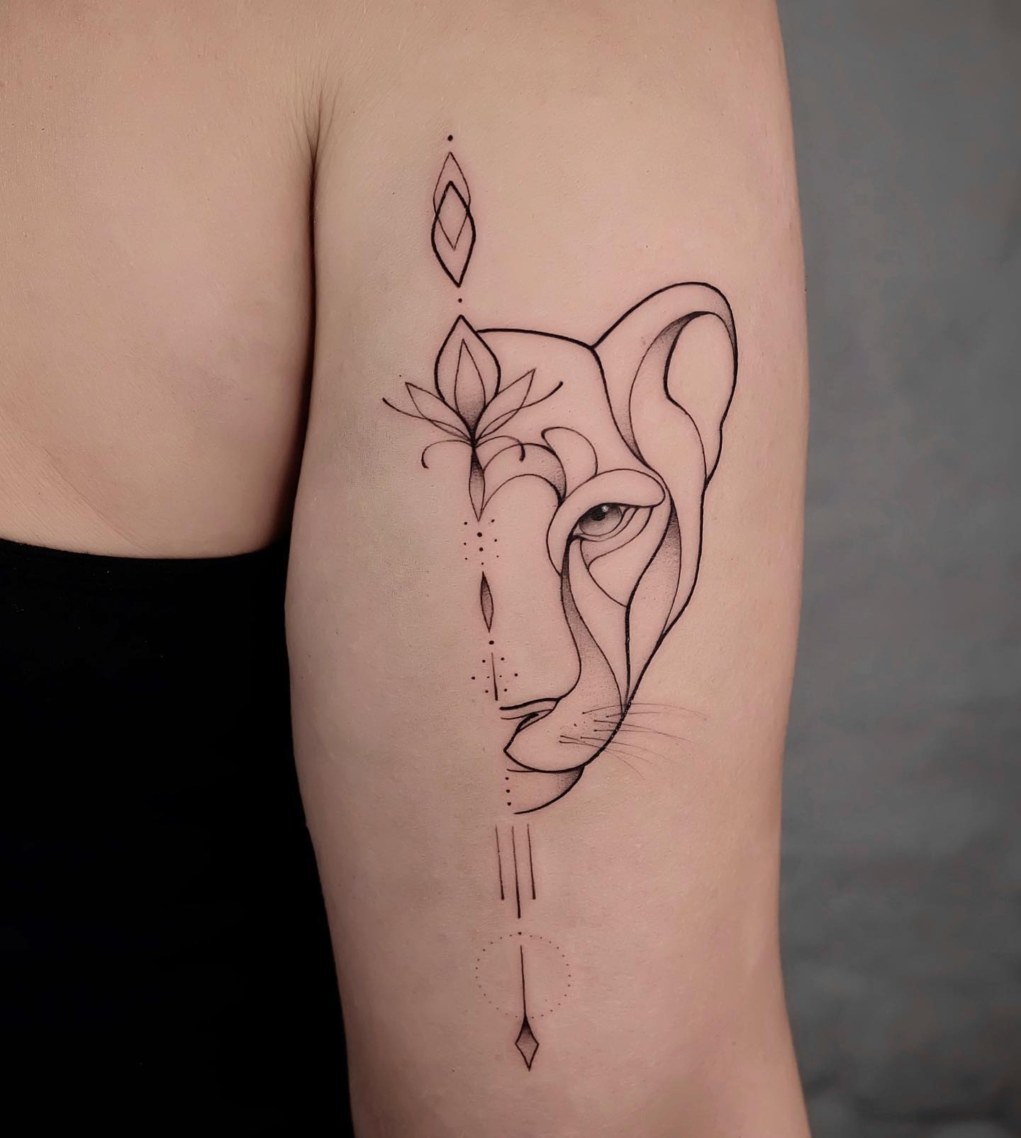 Line work style lioness tattoo on the arm