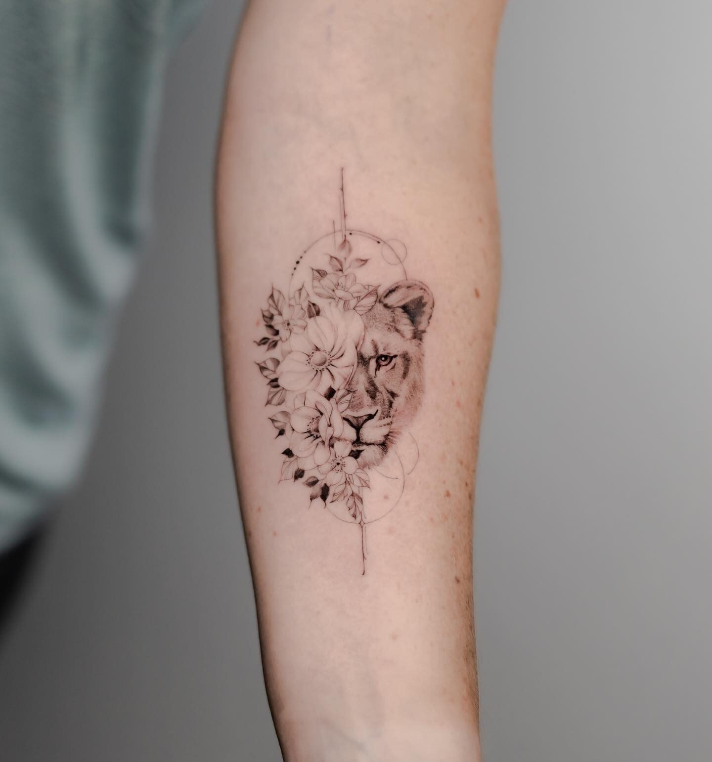 Lioness and flower tattoo on the inner forearm