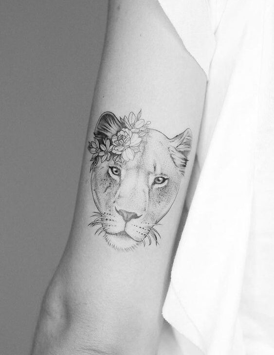 Lioness and flowers tattoo on the outer arm