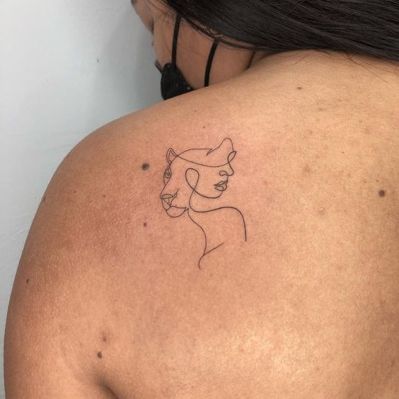 Single line lioness and face tattoo on the shoulder blade