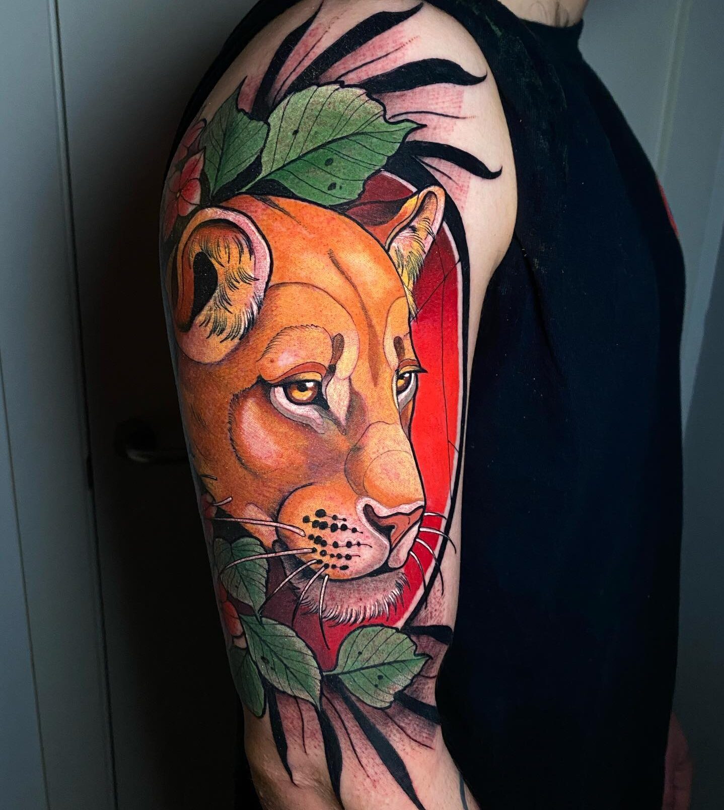 Colorful and vibrant lioness portrait tattoo on the arm