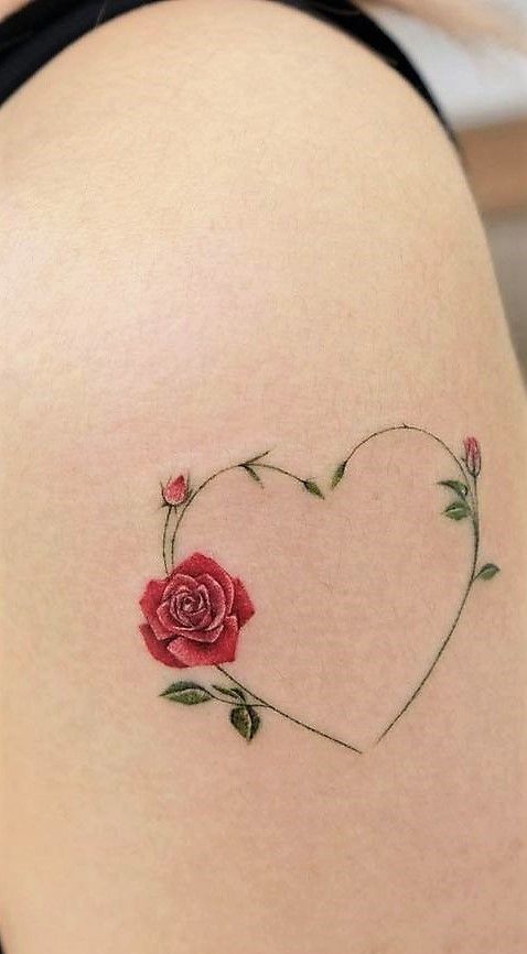 This may contain: a woman's thigh with a rose tattoo on it