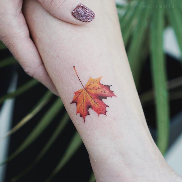 Small maple leaf tattoo on forearm