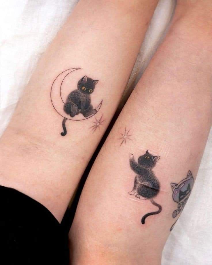 This may contain: two black cats sitting on top of each other's legs, with the moon and stars above them