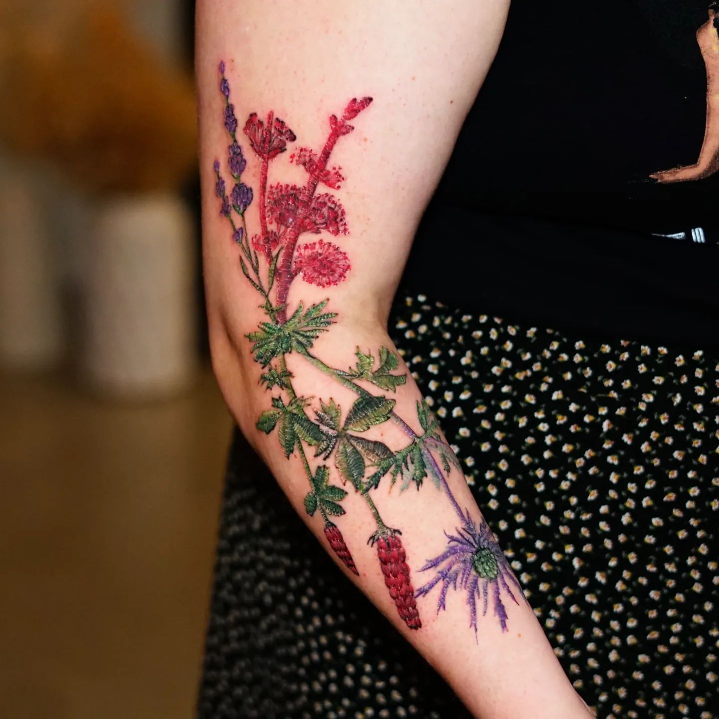 Embroidery style floral composition tattooed on the arm and forearm